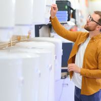 Monteur auf einer Leiter vor einer PV-anlage