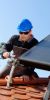 Solarthermie-Anlage und ein Monteur auf einem Dach