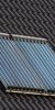 Solarthermie Vakuumröhren auf einem Dach neben einem Dachfenster