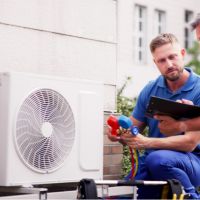 Monteur auf einer Leiter vor einer PV-anlage