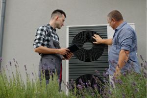 Ein Techniker und Hausbesitzer diskutieren die Genehmigung der Wärmepumpe.