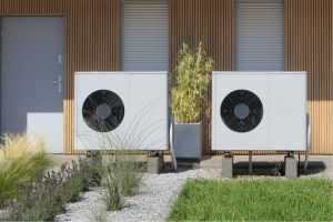 Zwei Wärmepumpen in einem Garten vor einem Haus