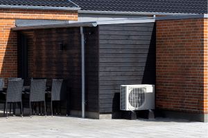 Wärmepumpe auf schwarzem Hinterhaus mit roten Ziegeln